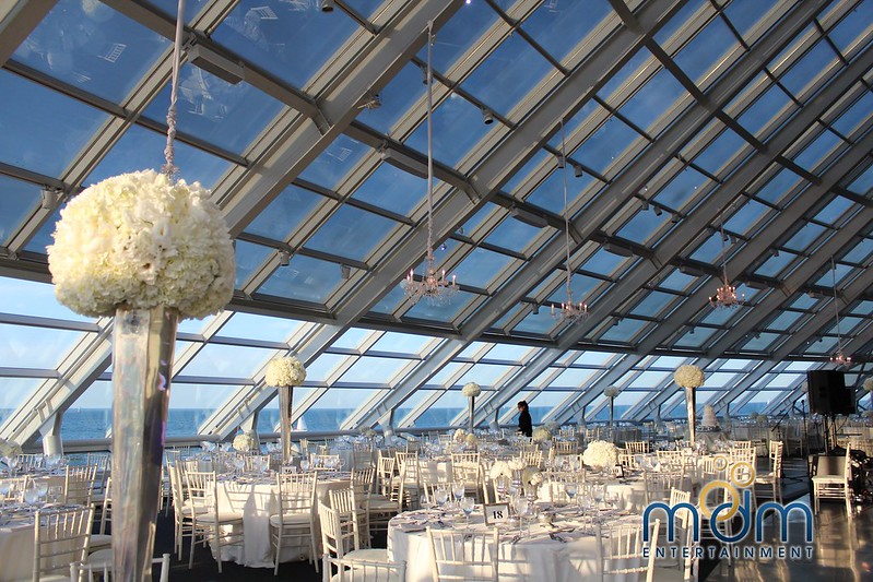 Tables And Chairs With White Floral Decor And Hanging Crystal Chandeliers Above