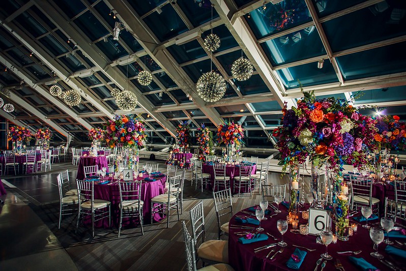 Tables And Chairs With Colorful Floral Decor And Hanging Sphere Chandeliers Above