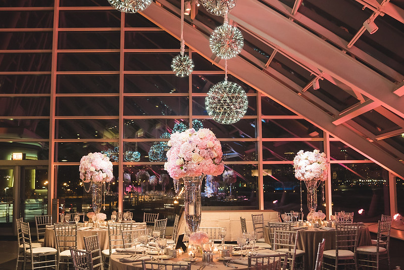 Tables And Chairs With Floral Decor And Hanging Sphere Chandeliers Above