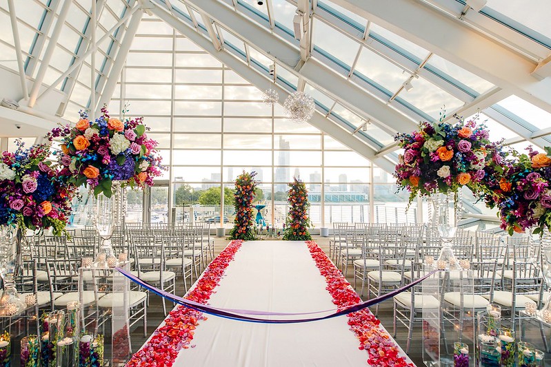 Aisle In The Solarium With White Carpet And Colorful Floral Decor