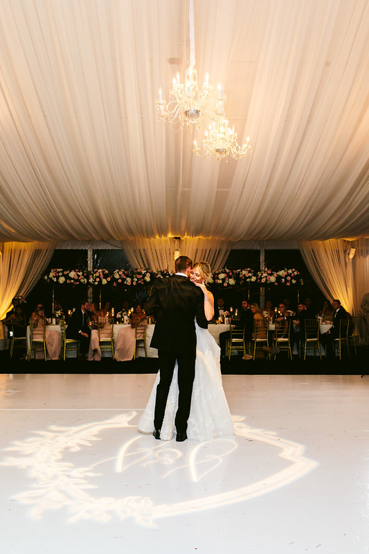Bride And Groom Dancing Under The Wedding Chandeliers With Monogram Gobo  Under Them