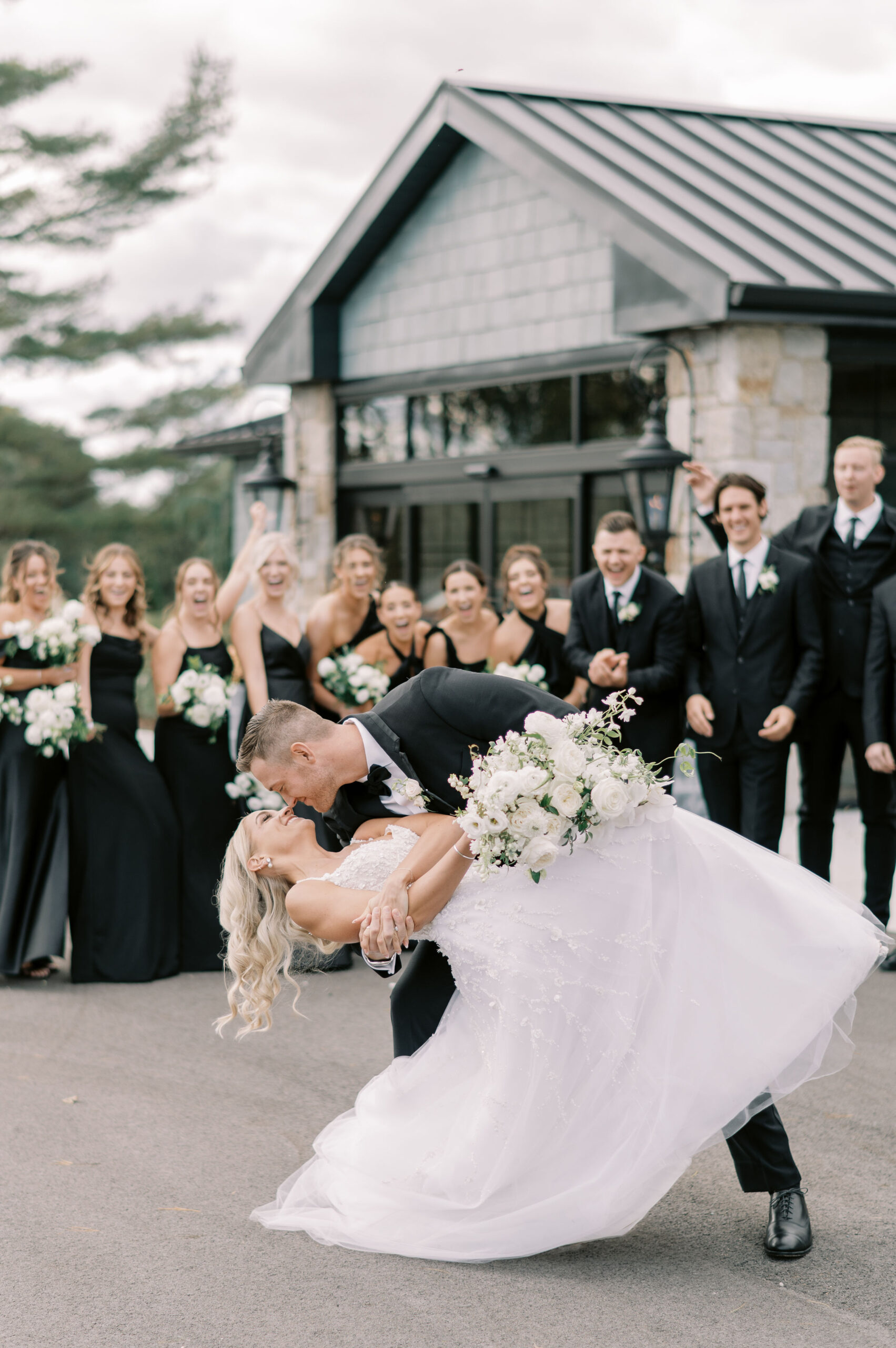 bride and groom sharing a kiss in front of their guests at their charming clubhouse wedding