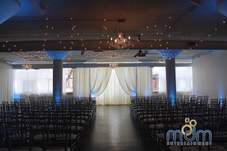Chicago Loft Wedding Venues, With White Drape, Blue Lighting, String Lights, And Hanging Chandeliers