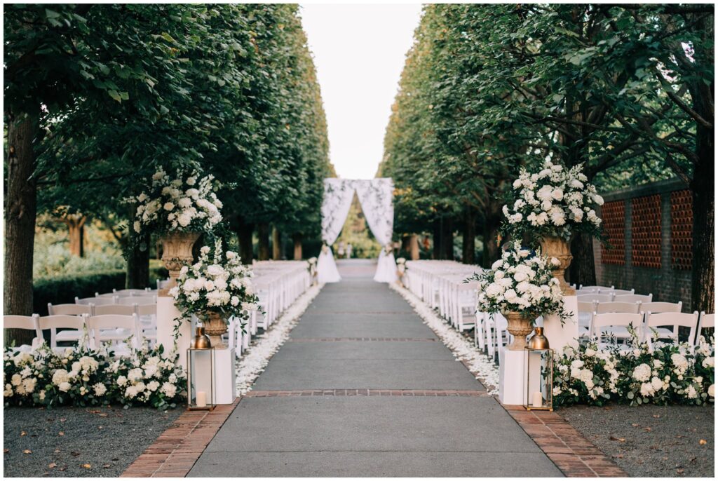 An Aisle, Chuppah Ceremony, White Florals, And White Chairs