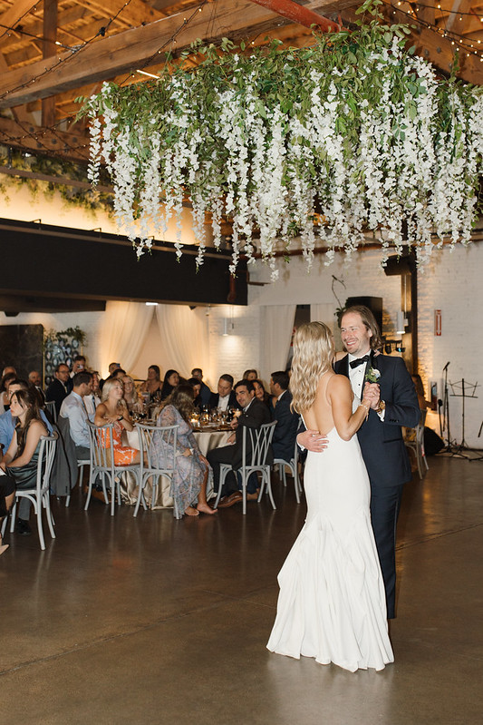 Bride And Groom Dancing At Their Walden Chicago Wedding With Greenery Above Them