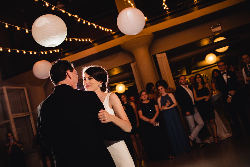 Bride And Groom Dancing Under The String Lights And Paper Lanterns