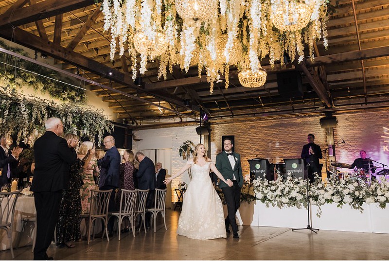 Bride And Groom Making An Entrance, Elegant Chandeliers Above Them