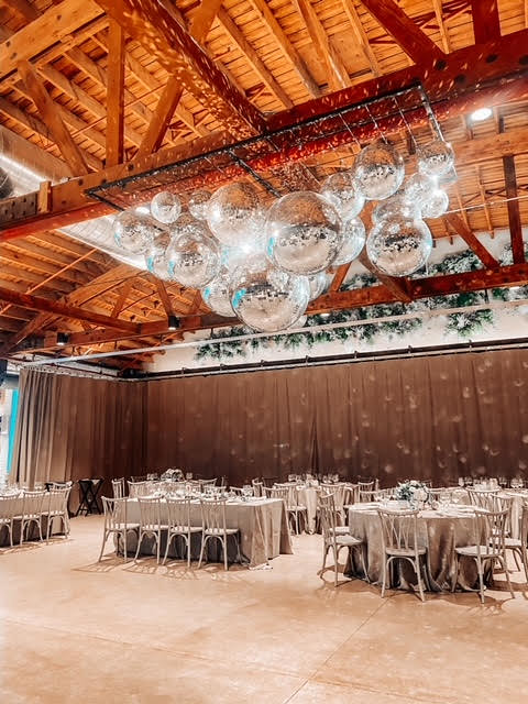 Hanging Mirror Balls, Drape Wall, And Tables And Chairs