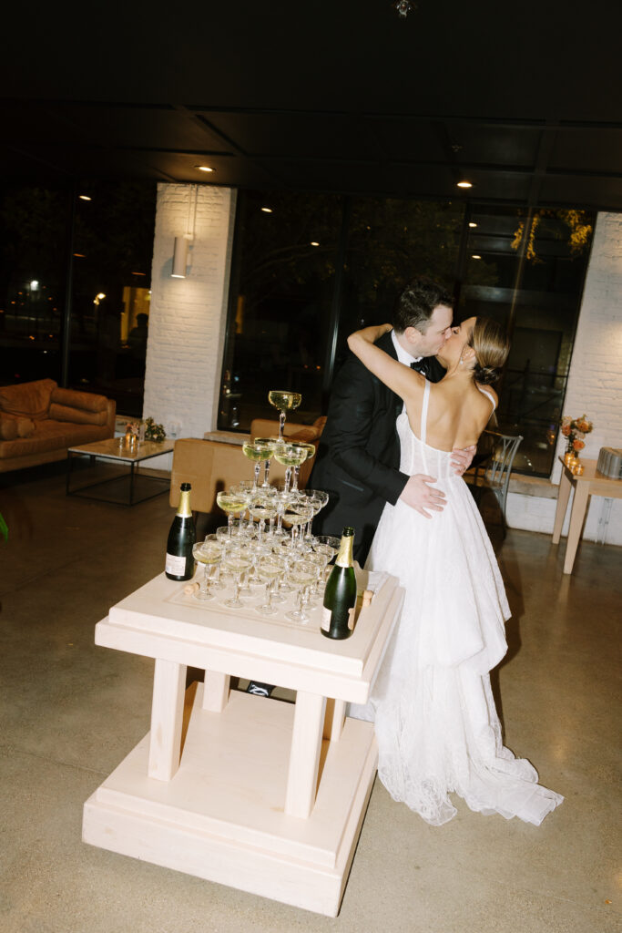 Hannah And Declan Kissing With Champagne Tower At Their Side