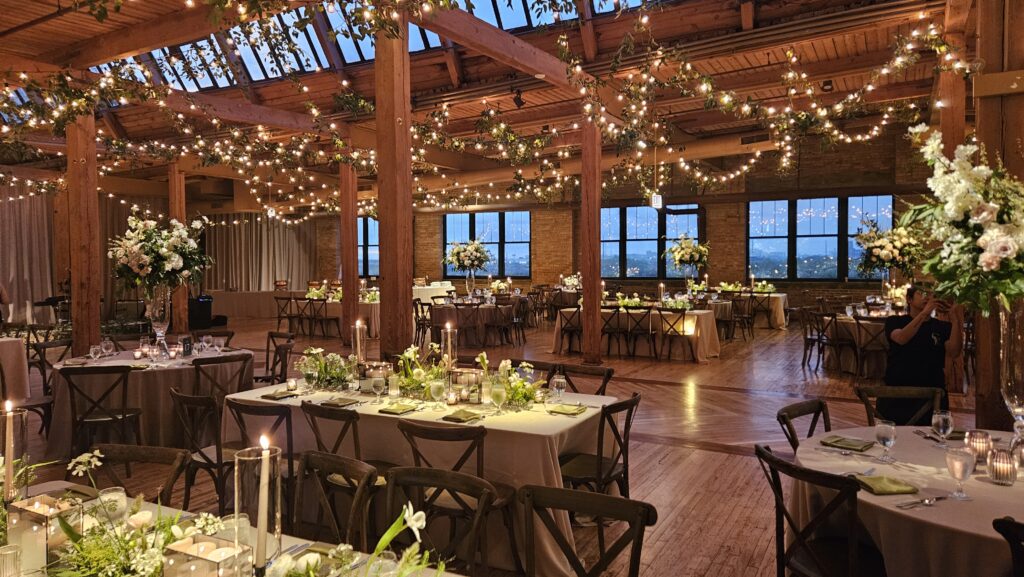 Skyline Loft With Flower Decor, Candles, And String Lights On The High Beam