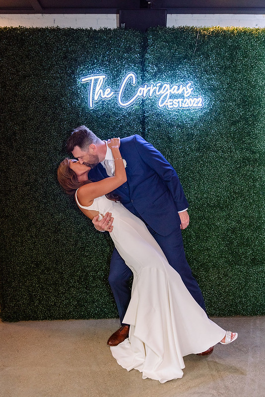 Bride And Groom With Greenery Wall As Their Backdrop