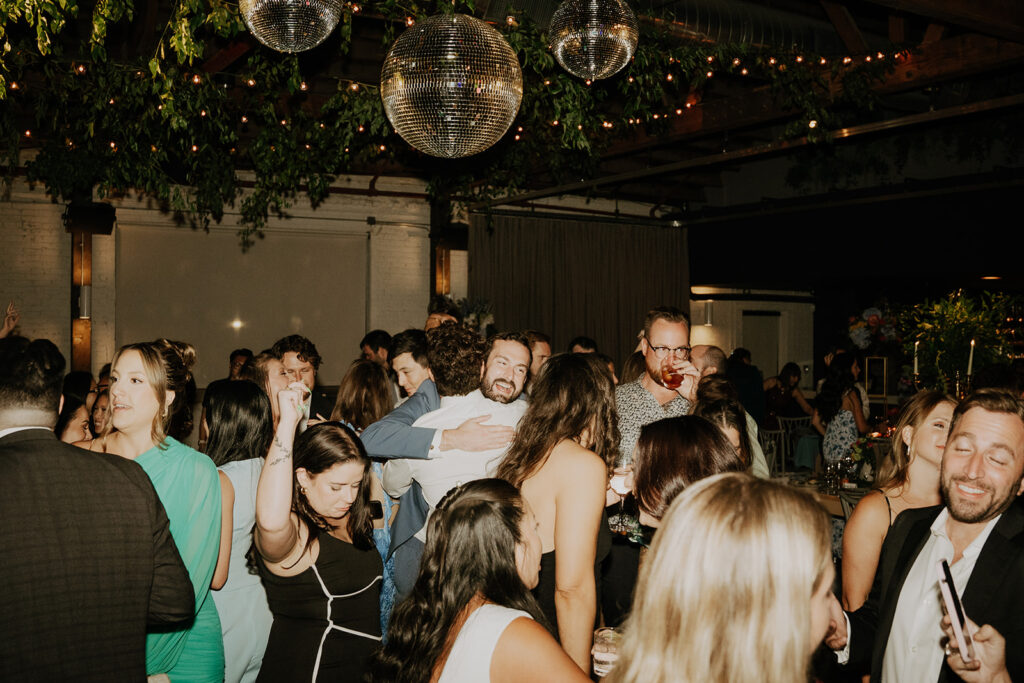 Guests Dancing Under The Mirror Balls And String Lights
