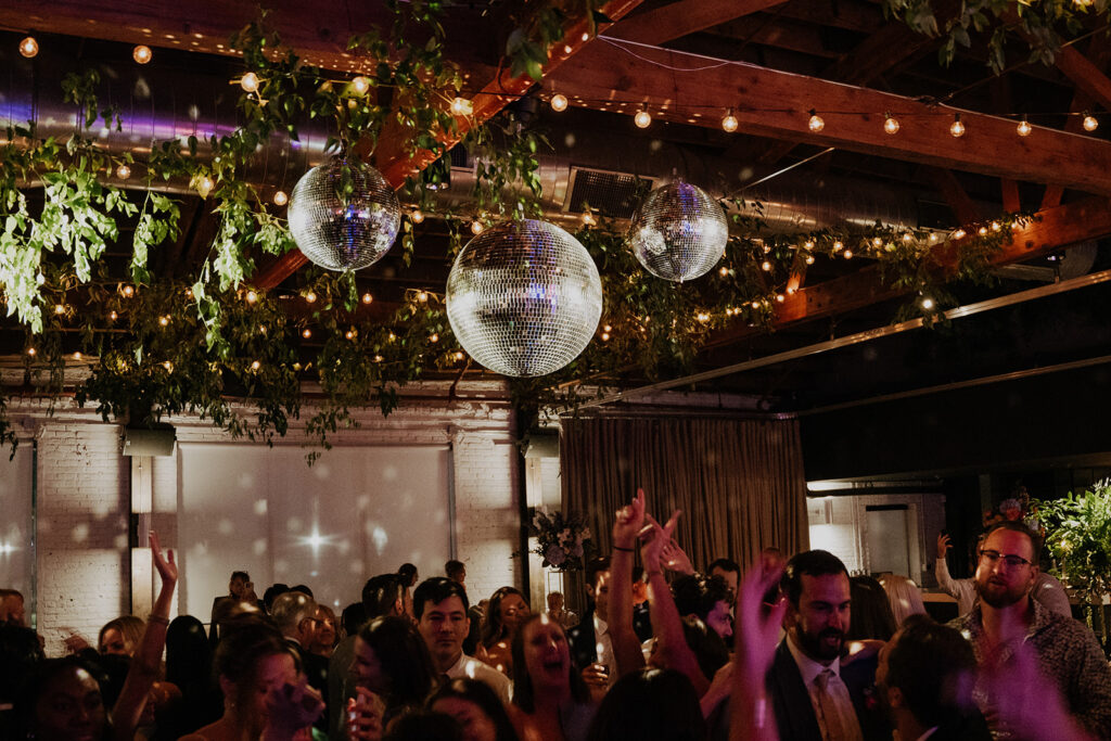 Guests Dancing Under The Mirror Balls And String Lights
