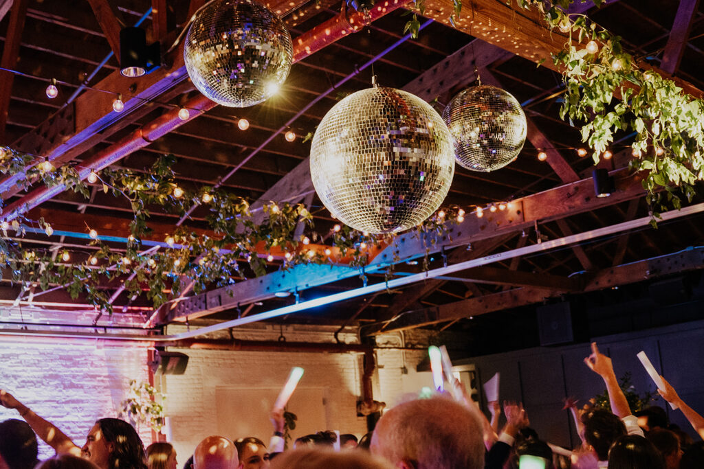 Guests Dancing Under The Mirror Balls And String Lights