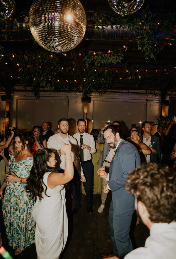 Guests Dancing Under The Mirror Balls And String Lights