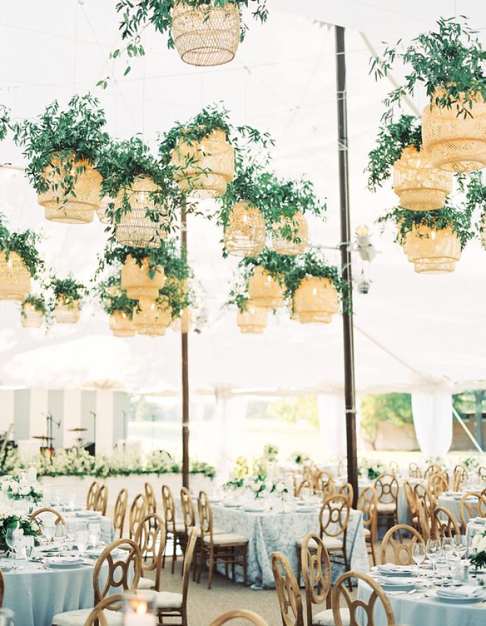 White Tent With White Tables And Wooden Chairs, Designed With Many Rattan Lantern Wedding Decor Above