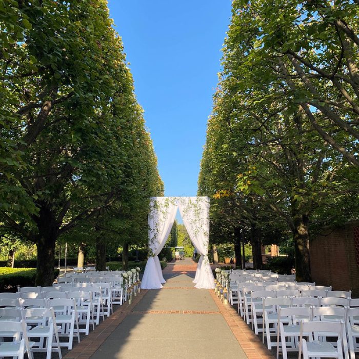 An Aisle, Chuppah Ceremony, White Florals, And White Chairs